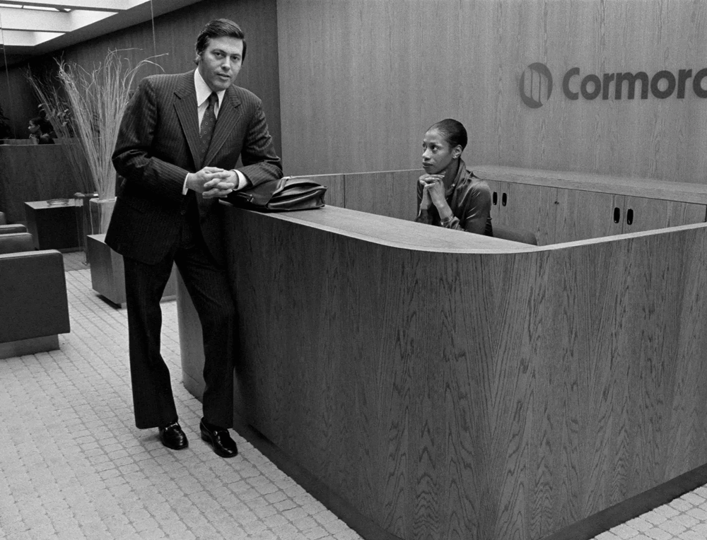 Man leans on receptionist desk at Cormorant Marketing's Jacksonville FL aviation digital marketing agency