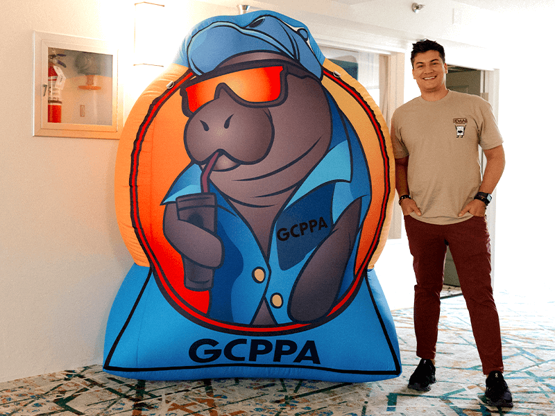 Goldie Float A man smiles and poses beside an inflatable logo display for GCPPA by Cormorant Marketing