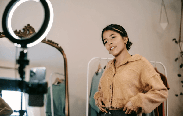 Jacksonville real estate marketing A woman looks at ring light, looking happy, working on social media marketing servies for jacksonville fl real estate agents