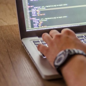 Aviation Web Design Web developer coding an aviation website on a laptop, showcasing HTML and CSS during the aviation website development process